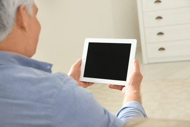 Man using video chat on tablet at home, closeup. Space for text - 写真・画像