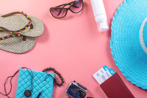 Туристические принадлежности для отдыха: шляпа, солнцезащитные очки, паспорт фотоаппарата и авиабилеты на розовом фоне. Вид сверху. Плоский лежал
 - Фото, изображение