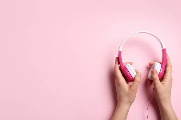 Woman holding stylish headphones on color background, closeup. Space for text - Φωτογραφία, εικόνα