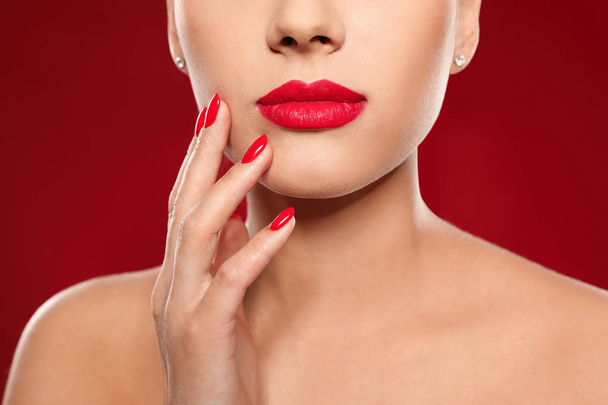 Beautiful young woman with bright manicure on color background, closeup. Nail polish trends - 写真・画像