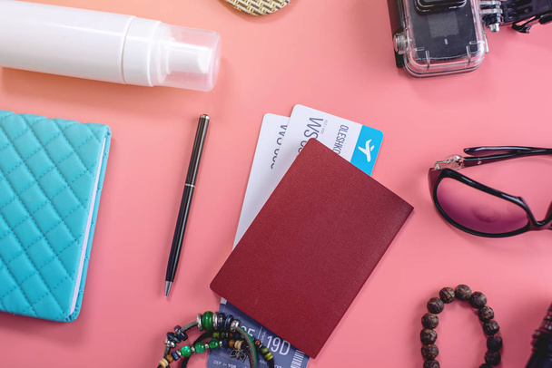 Seyahat tatil malzemeleri: şapka, güneş gözlüğü, kamera, pasaport ve pembe arka plan üzerinde uçak biletleri. Üst te. Düz yatıyordu - Fotoğraf, Görsel