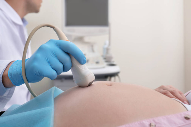 Schwangere unterzieht sich Ultraschalluntersuchung in Klinik, Nahaufnahme - Foto, Bild