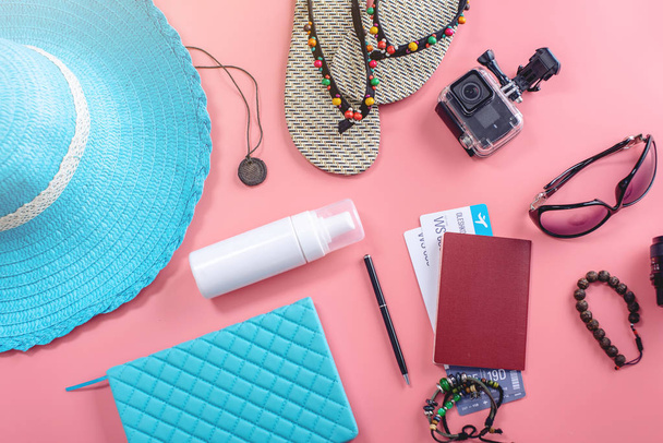 Туристические принадлежности для отдыха: шляпа, солнцезащитные очки, фотоаппарат, паспорт и авиабилеты на розовом фоне. Вид сверху. Плоский лежал
 - Фото, изображение