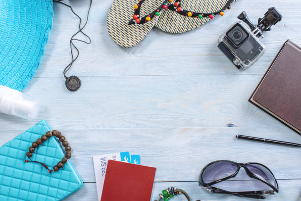 旅行の休日用品:帽子、サングラス、フリップフロップ、カメラ、青い背景にパスポート。トップビュー。フラットレイ - 写真・画像
