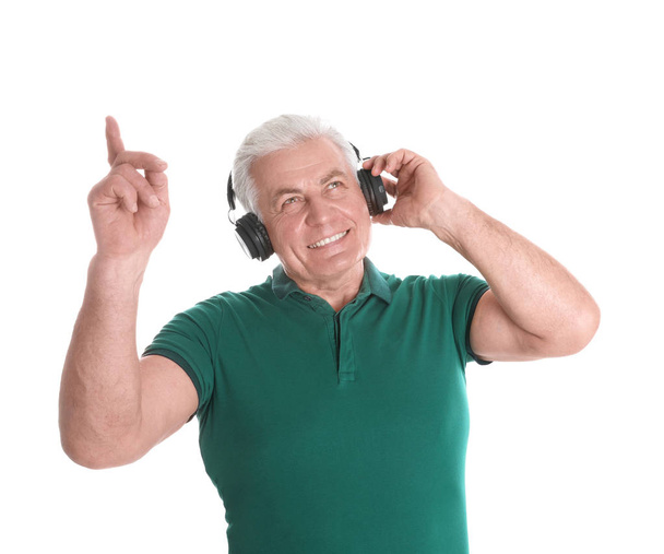 Mature man enjoying music in headphones on white background - Foto, Imagen
