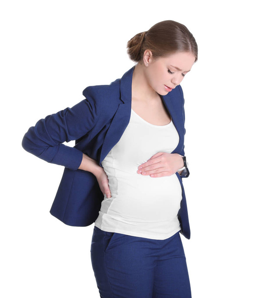 Young pregnant woman suffering from pain on white background. Working while expecting baby - Foto, imagen
