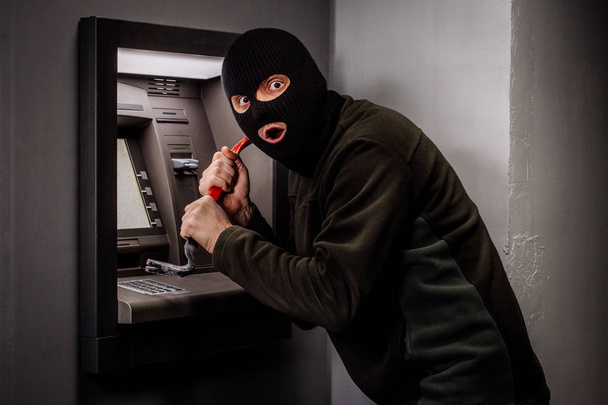 thief with crowbar opens the ATM.  - Foto, Bild