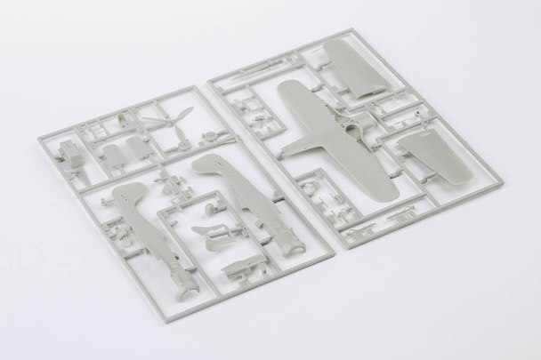 kit for assembling gray plastic airplane model on white bsckgrou - Photo, image