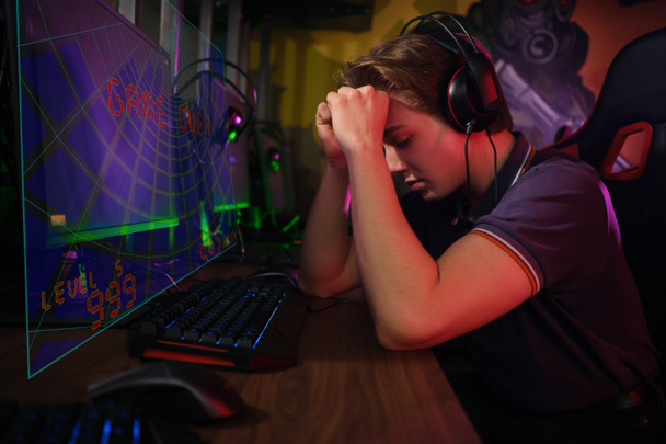 Profesional joven jugador caucásico jugando en línea en su PC. Se enfadó por haber perdido el juego.
 - Foto, imagen