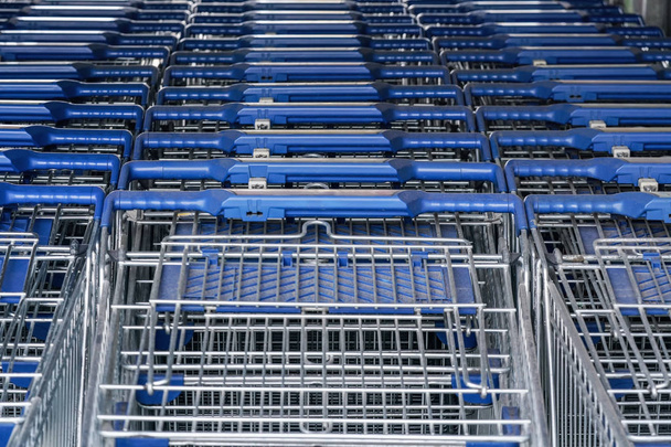 Closeup of metal shopping carts stacked in front of shop mall - Fotografie, Obrázek