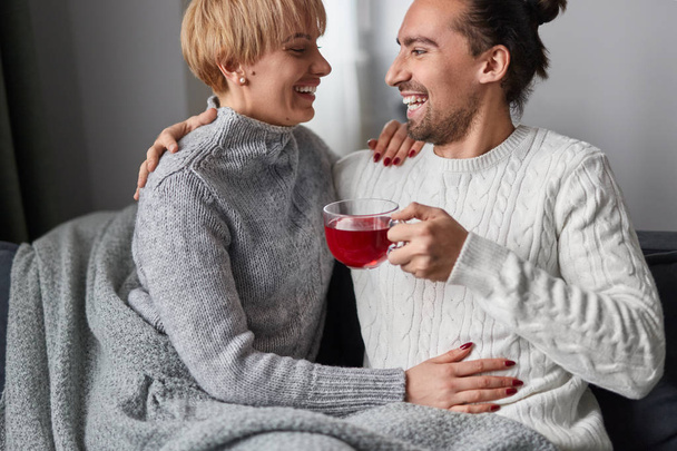 Happy couple drinking red tea on couch - Valokuva, kuva