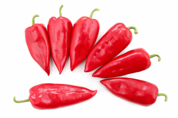 sieben leuchtend rote Paprika auf weißem Hintergrund - Foto, Bild