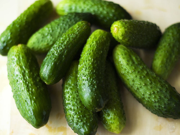 Verse zelfgemaakte komkommers, kleine augurken uit de tuin op tafel - Foto, afbeelding