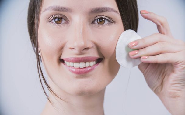 Woman using cotton pad. Healthy skin brunette woman closeup face clean healthy skin - Fotó, kép