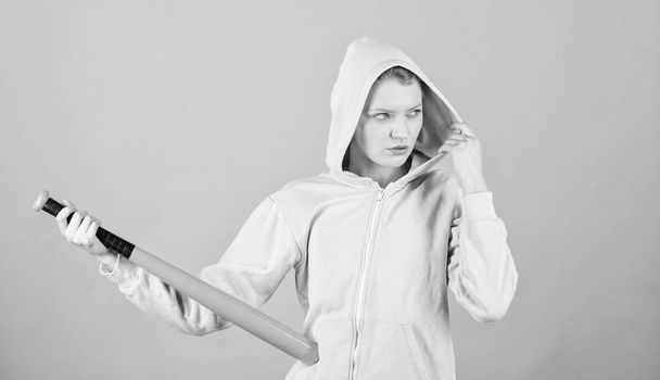 Woman play baseball game or going to beat someone. Girl hooded jacket hold baseball bat blue background. Woman in baseball sport. Baseball female player concept. Feeling power. She is dangerous - Foto, immagini