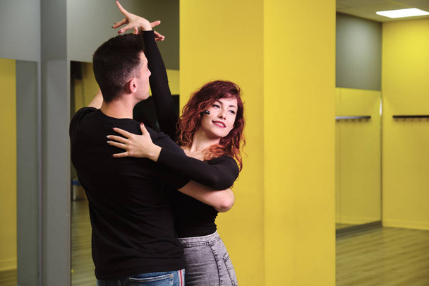 Een jonge vrouw en een man onderwijzen salsa en Bachata - Foto, afbeelding