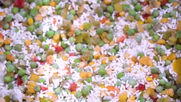Heerlijke bevroren Hawaiiaanse mix van rijst en groenten in een supermarkt koelkast close-up. Plantaardig halffabricaat van rijst, groene erwten, maïs, Bulgaarse rode en gele peper in de markt. - Video