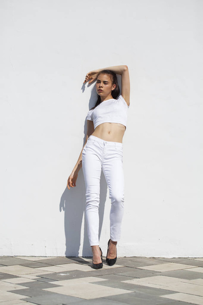 Model tests. Young beautiful brunette model posing against a whi - Фото, изображение