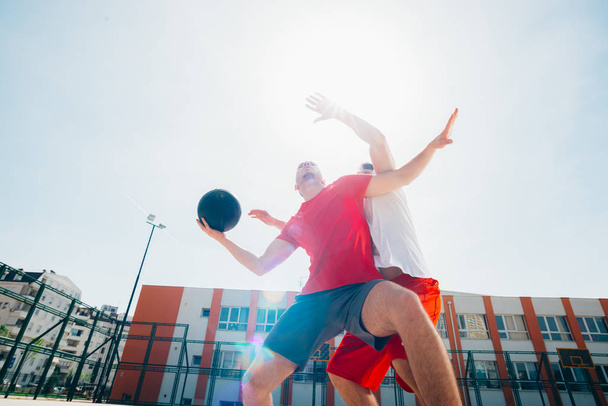 Dwa mocne męskie koszykarki grają w piłkę z drzwiami walczących  - Zdjęcie, obraz