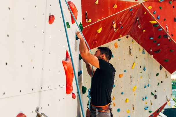 Giovane uomo sportivo arrampicata sulla parete pratica monte all'aperto
 - Foto, immagini