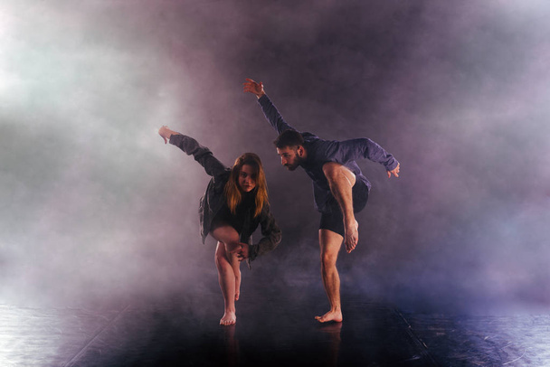 2人の現代のダンサーが靴のない足を高く伸ばす - 写真・画像