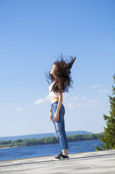 Beautiful brunette woman posing against blue sky bright sunny we - Фото, изображение