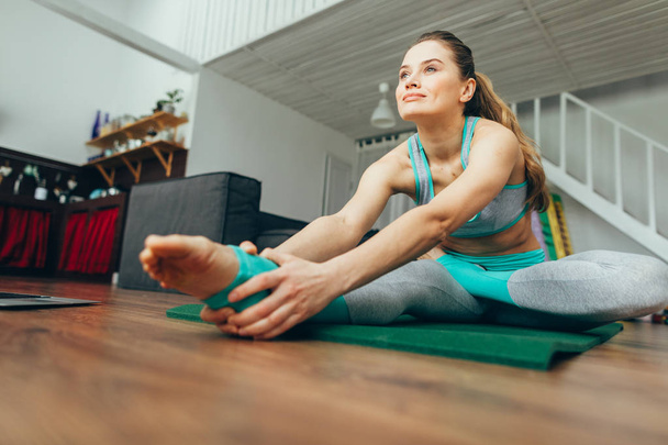 Attractive woman practicing head to knee yoga pose - Фото, изображение