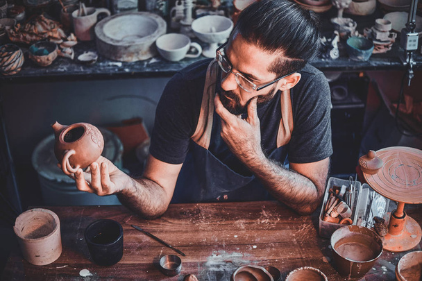 Skeptik se dívá na svou práci, keramický čajník. - Fotografie, Obrázek