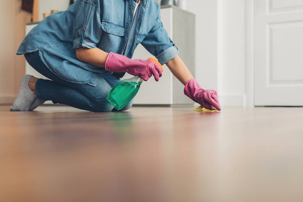 Female cleaning wooden floor surface at home - Foto, immagini