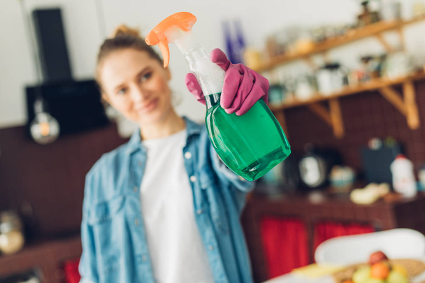 Happy woman showing spray detergent in hand - Zdjęcie, obraz
