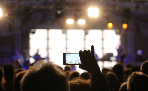 person records a video of the concert with the smartphone - Photo, Image