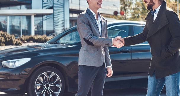 Photo of two smart elegant men, which have a deal about car. - 写真・画像
