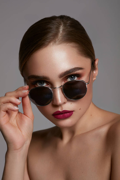 Portrait of young girl wear sunglasses isolated over gray  - Foto, imagen