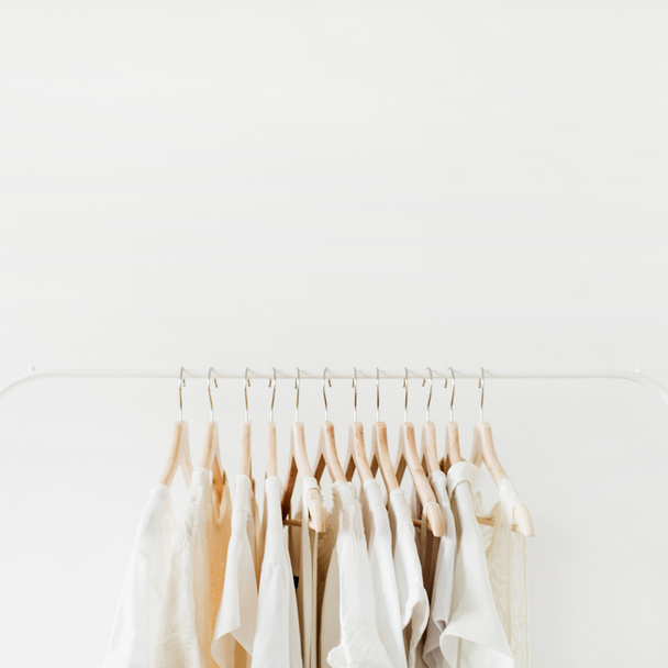 Minimal fashion clothes concept. Female blouses and t-shirts on hanger on white background. Fashion blog, website, social media hero header template. - Fotografie, Obrázek