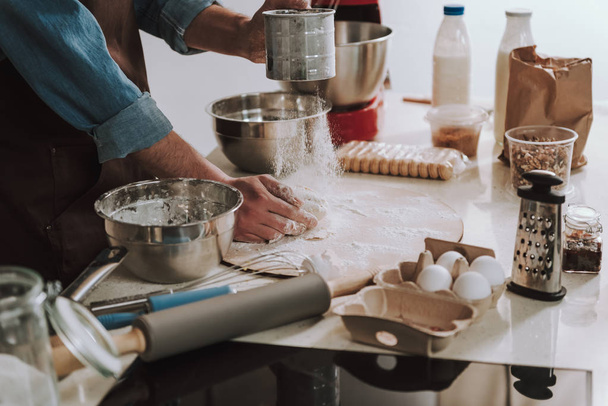 Person sifting flour on the dough while cooking - Fotoğraf, Görsel