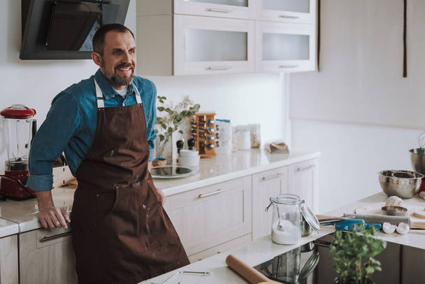 Cheerful man smiling while resting in the kitchen - Valokuva, kuva