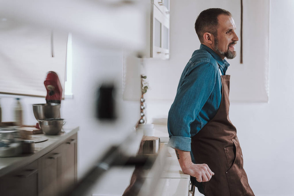 Waist up of man standing with hands on the countertop - Foto, Imagem