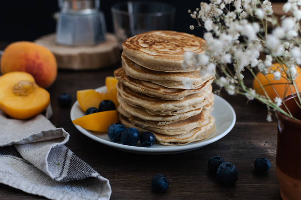 Beautiful rustic breakfast - pancakes with blueberries, peach, G - Photo, Image