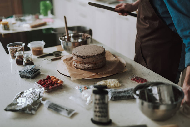 Krásný krémový dort stojící na pečicím papíře na stole - Fotografie, Obrázek