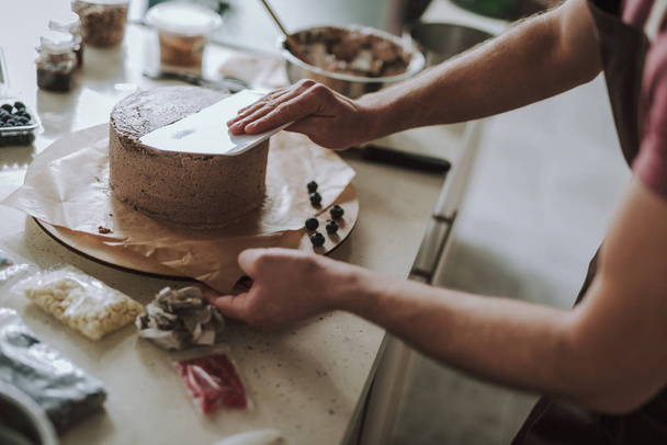 Hands of professional confectioner smoothing the cake - Fotografie, Obrázek