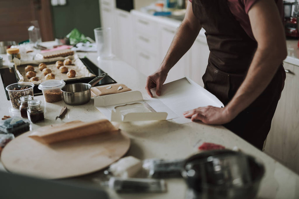Hands of man making carton box in the kitchen - Foto, imagen