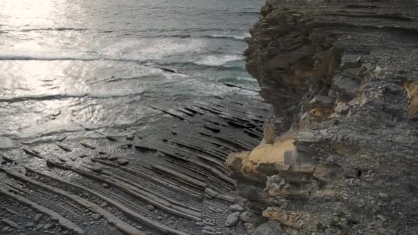 Kleine golven die tegen een rotsformatie crashen - Video