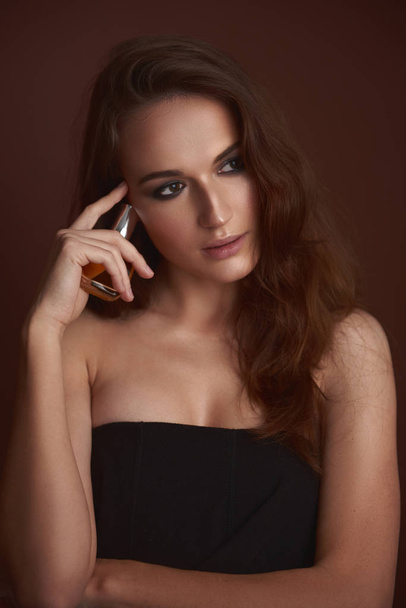 Beautiful young woman with smokey eyes makeup holding perfume - Fotoğraf, Görsel