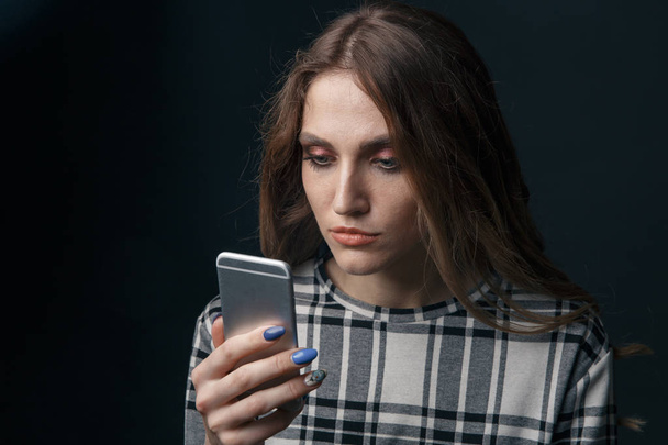 Smutny nastolatków istota ofiara z cyber nękanie online siedzący na a tapczan w The żywy pokój w - Zdjęcie, obraz
