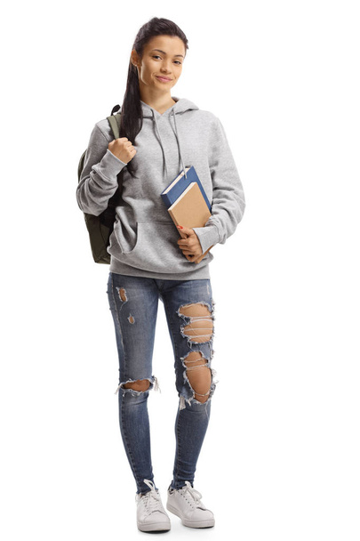 Молода жінка з рюкзаком і книгами посміхається в камеру
  - Фото, зображення