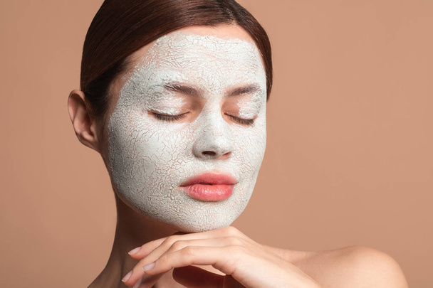 Peaceful lady using clay mask with her eyes closed - Foto, Bild