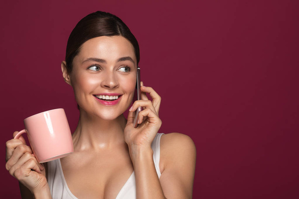 Cheerful woman looking away and smiling while having phone talk - Photo, Image