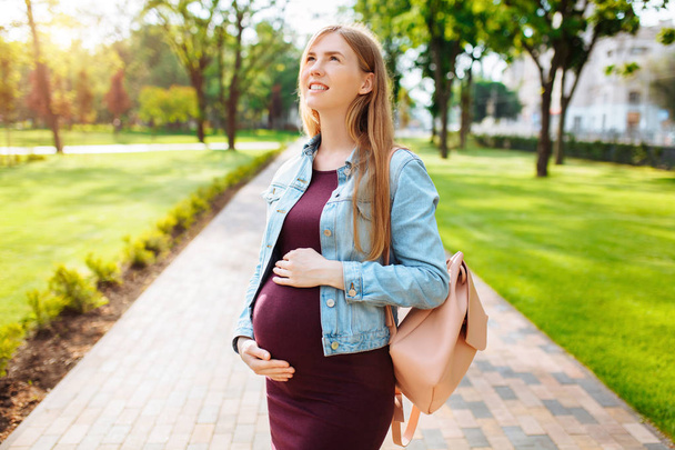 Beautiful pregnant girl student happily looking into the sky, wa - Fotografie, Obrázek