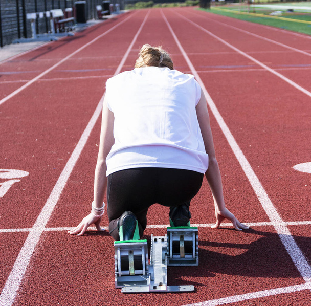 Kobieta sprinter w blokach początkowych od tyłu - Zdjęcie, obraz