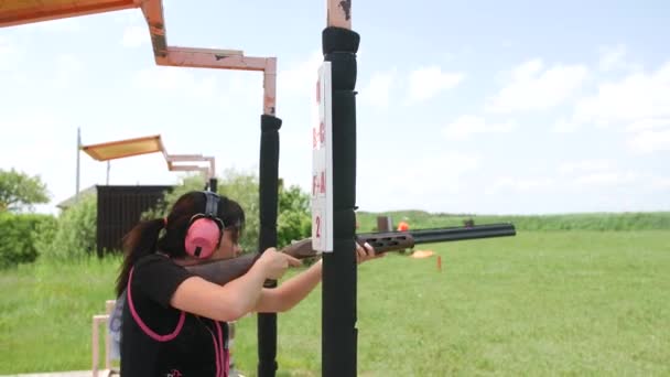 若い美少女は射的場で空飛ぶ標的を撃つトラップ射撃 - 映像、動画